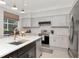 Modern kitchen features stainless appliances, gray cabinets, white subway tile backsplash, and large window at 3821 Turkey Oak Dr, Valrico, FL 33596