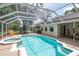 A screened pool and hot tub with patio, lounge chairs, grill, and access to the main house at 3821 Turkey Oak Dr, Valrico, FL 33596