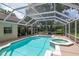 A screened pool with a connecting hot tub and patio with access to the main house at 3821 Turkey Oak Dr, Valrico, FL 33596