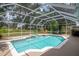 A screened pool with lounge chairs and a hot tub, surrounded by lush greenery at 3821 Turkey Oak Dr, Valrico, FL 33596