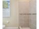 Bathroom featuring neutral tile, window with blinds, and modern toilet at 4089 Windcrest Dr, Wesley Chapel, FL 33544