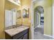 Bathroom featuring granite countertop, dark wood cabinets, and access to a tiled shower at 4089 Windcrest Dr, Wesley Chapel, FL 33544