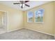 Comfortable bedroom with neutral carpet, ceiling fan, and two windows offering outside views at 4089 Windcrest Dr, Wesley Chapel, FL 33544