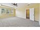 Bedroom features neutral paint and carpet, with tray ceiling, ceiling fan, and walk-in closet at 4089 Windcrest Dr, Wesley Chapel, FL 33544
