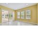 Bright dining area with tile flooring, sliding glass doors to patio, and natural light from three windows at 4089 Windcrest Dr, Wesley Chapel, FL 33544