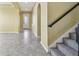 Foyer featuring a stairway with carpeted steps and a wrought iron railing, adjacent to the front entry at 4089 Windcrest Dr, Wesley Chapel, FL 33544