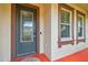 Elegant front door with decorative glass and matching sidelight windows framed with dark brown trim at 4089 Windcrest Dr, Wesley Chapel, FL 33544
