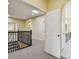 Carpeted hallway with an arched doorway view of the bathroom and ornamental iron railing at 4089 Windcrest Dr, Wesley Chapel, FL 33544