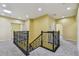 View of the carpeted hallway with ornamental iron railing, recessed lighting, and neutral walls at 4089 Windcrest Dr, Wesley Chapel, FL 33544
