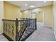 Second floor hallway with ornamental iron railing, carpeted floors, and recessed lights at 4089 Windcrest Dr, Wesley Chapel, FL 33544