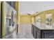 Open kitchen with stainless refrigerator, tile floors, large island, and views to the living room at 4089 Windcrest Dr, Wesley Chapel, FL 33544