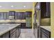 Gourmet kitchen with stainless steel appliances, double ovens, granite countertops, island, and dark wood cabinets at 4089 Windcrest Dr, Wesley Chapel, FL 33544