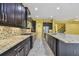The gourmet kitchen features granite counters, a center island, stainless appliances, and dark wood cabinets at 4089 Windcrest Dr, Wesley Chapel, FL 33544