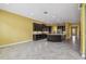 Spacious living area showcases an open-concept design with tile floors and kitchen with dark cabinetry at 4089 Windcrest Dr, Wesley Chapel, FL 33544