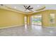 Bright living room with decorative ceiling, neutral tile flooring, and sliding glass doors to the lanai at 4089 Windcrest Dr, Wesley Chapel, FL 33544