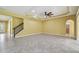 Expansive living room with tile flooring, staircase, and an archway leading to a bathroom at 4089 Windcrest Dr, Wesley Chapel, FL 33544