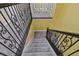 Staircase with gray carpet and decorative wrought iron railing at 4089 Windcrest Dr, Wesley Chapel, FL 33544