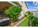 Side yard featuring lush greenery, manicured lawn, and garden area with brick border at 4089 Windcrest Dr, Wesley Chapel, FL 33544