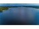 Expansive aerial view of a serene blue lake bordered by verdant forests and distant horizons at 4133 Auston Way, Palm Harbor, FL 34685