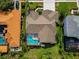 Aerial view of a single Gathering house featuring a screened-in pool and a well-manicured backyard at 4133 Auston Way, Palm Harbor, FL 34685