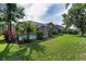 Manicured backyard with lush green lawn and screened-in pool area, offering a private outdoor space at 4133 Auston Way, Palm Harbor, FL 34685