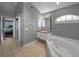 Bathroom with tiled floor, tub, and vanity with good lighting, and view to the main bedroom at 4133 Auston Way, Palm Harbor, FL 34685
