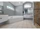 Large bathroom featuring double sink vanity, tiled floors, and a corner jacuzzi tub at 4133 Auston Way, Palm Harbor, FL 34685