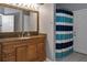 Bathroom featuring granite counters, a wooden vanity and a blue and white striped shower curtain at 4133 Auston Way, Palm Harbor, FL 34685