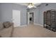 Bedroom with carpet, ceiling fan, two windows, couch and cabinet for media storage at 4133 Auston Way, Palm Harbor, FL 34685