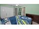 Bedroom with mint-green walls features a closet and a ladder next to the door, and leads to a bathroom at 4133 Auston Way, Palm Harbor, FL 34685