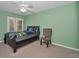 Green bedroom with fan, plantation shutters, and cozy seating area with an inviting bed at 4133 Auston Way, Palm Harbor, FL 34685