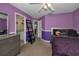This bedroom features purple walls, closet and a view to the sink area in the bathroom at 4133 Auston Way, Palm Harbor, FL 34685
