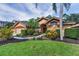 Charming single-story home featuring a landscaped front yard, a double-door entry, and a three-car garage at 4133 Auston Way, Palm Harbor, FL 34685