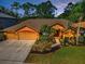Inviting single-story home with a three-car garage and lush landscaping at 4133 Auston Way, Palm Harbor, FL 34685