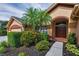 This single-story home features a double-door entry, lush landscaping, and a paved walkway at 4133 Auston Way, Palm Harbor, FL 34685