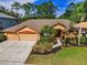Inviting single-story home with a three-car garage and lush landscaping at 4133 Auston Way, Palm Harbor, FL 34685