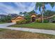 Charming single-story home featuring a landscaped front yard, a double-door entry, and a three-car garage at 4133 Auston Way, Palm Harbor, FL 34685