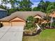 Inviting single-story home with a three-car garage and lush landscaping at 4133 Auston Way, Palm Harbor, FL 34685