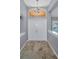 Bright foyer featuring neutral paint, tile floors, transom window and elegant chandelier at 4133 Auston Way, Palm Harbor, FL 34685