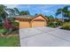 A lovely street view of the home, featuring a large driveway and spacious 3-car garage at 4133 Auston Way, Palm Harbor, FL 34685