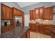 Cherry wood kitchen featuring granite countertops, stainless steel appliances, and a spacious island at 4133 Auston Way, Palm Harbor, FL 34685
