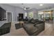 Comfortable living room with gray sofa and sliding glass doors leading to the lanai and pool at 4133 Auston Way, Palm Harbor, FL 34685