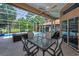 Covered patio area with a dining table and outdoor furniture overlooks the pool and landscaped backyard at 4133 Auston Way, Palm Harbor, FL 34685