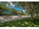 A community playground provides recreational space with play equipment, picnic tables, and a covered seating area amidst green surroundings at 4133 Auston Way, Palm Harbor, FL 34685