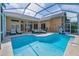 Spacious screened-in patio area with a pool and lounge furniture, ideal for outdoor relaxation and entertainment at 4133 Auston Way, Palm Harbor, FL 34685