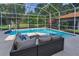 Screened-in pool with lounge seating area and lush backyard landscaping at 4133 Auston Way, Palm Harbor, FL 34685