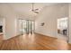 Open living room featuring wood floors, a ceiling fan, and sliding glass doors leading to outdoor pool area at 4303 Kipling Ave, Plant City, FL 33566