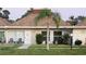 Charming single-story home with a well-manicured lawn, palm tree, and cozy front porch seating at 4324 Tahitian Gardens Cir # J, Holiday, FL 34691
