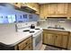 Traditional kitchen featuring wood cabinetry, white appliances, and a double basin sink at 4324 Tahitian Gardens Cir # J, Holiday, FL 34691