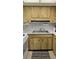 Kitchen features wood cabinets, a double basin sink, and essential appliances at 4324 Tahitian Gardens Cir # J, Holiday, FL 34691
